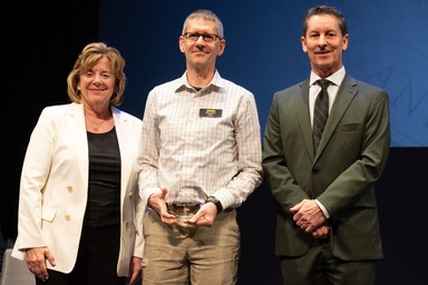 Honors Program Director Shaun Vecera, center, receives the 2025 Lola Lopes Award for Student Advocacy, flanked by President Sally Mason and Provost Kevin Kregel. Vecera serves on the team who selects the honors students who are awarded named, endowed scholarships.