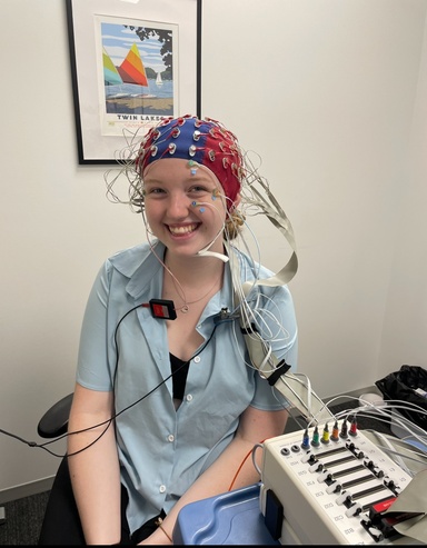 Ellie Wojcikowski wears an Electroencephalography (EEG) cap to record brain waves using electrodes placed on the scalp, contributed by Wojcikowski. Wojcikowski is a senior at the University of Iowa and has been involved in research all four years of her undergraduate experience, both assisting and participating in it.